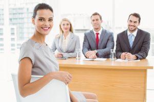 A woman wearing business clothes and three people in front of her