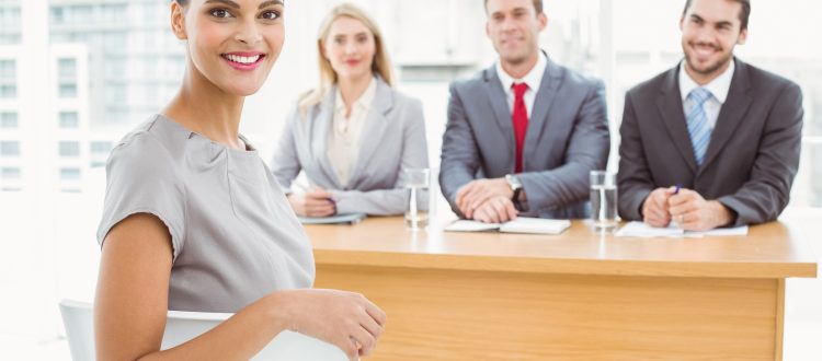 A woman wearing business clothes and three people in front of her